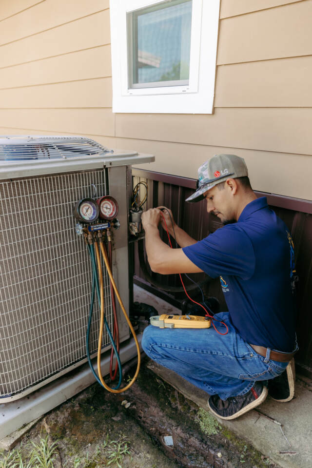 technician performing spring a/c tune up with meter testing part