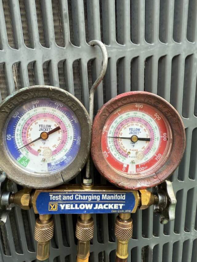 Guages connected showing refrigerant levels very low