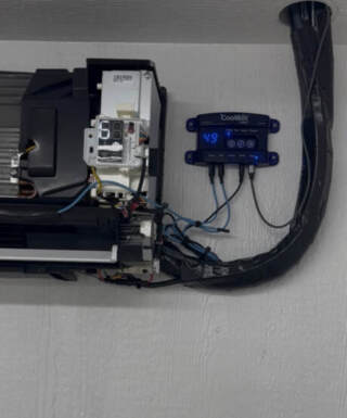 The shows one of the indoor units with the cover removed and a Cool Bot Pro added to it
