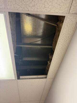 The indoor unit stuffed up in the attic above commercial ceiling tiles