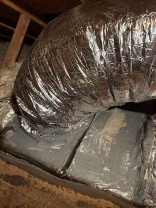 Picture of new duct on and showing the unit has been air sealed with mastic
