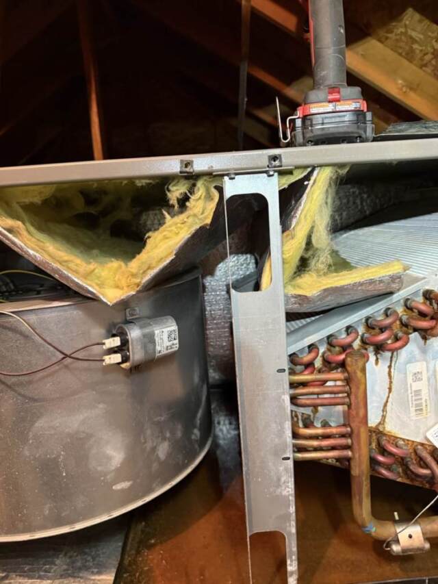 Looking inside the airhandler before the repair showing the insulation being sucked into the blower