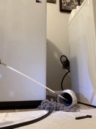 Dryer vent cleaning brush is inserted in the dryer hose and it is cleaning it out.