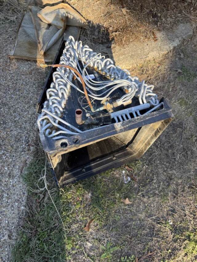 Evaporator coil removed from unit laying in yard