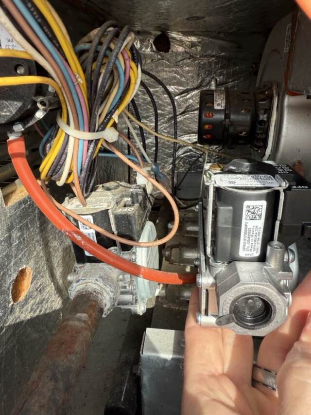 Inside the heating section of the system showing the old and new gas valve.